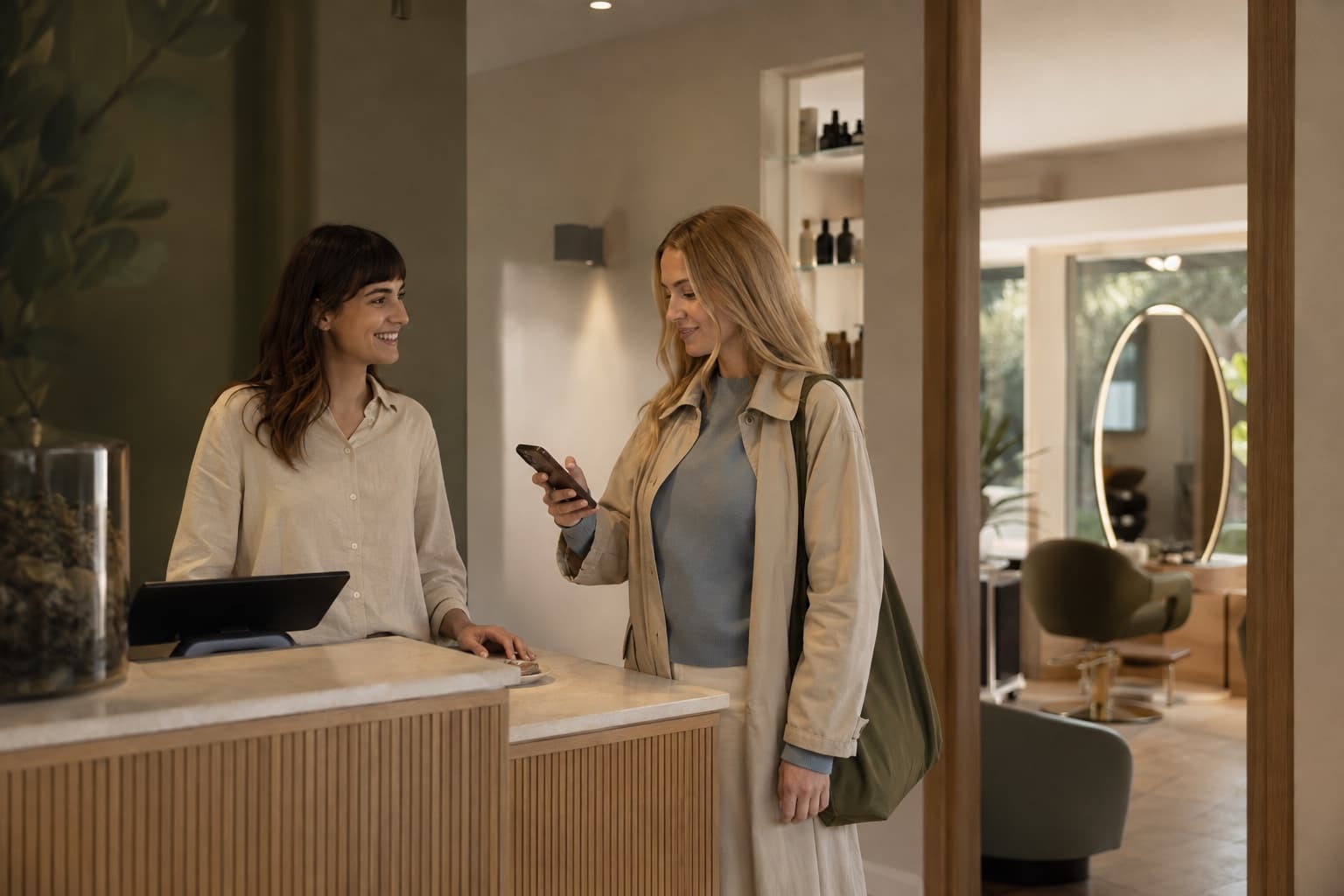A salon receptionist and client checking the next appointment together
